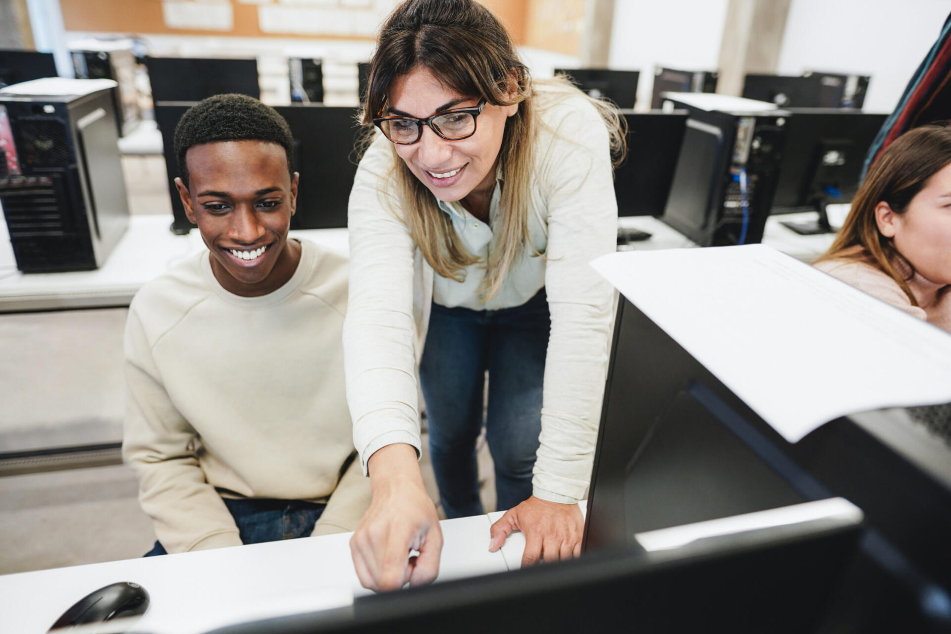 Teacher working with students inside computer room - Focus on woman face